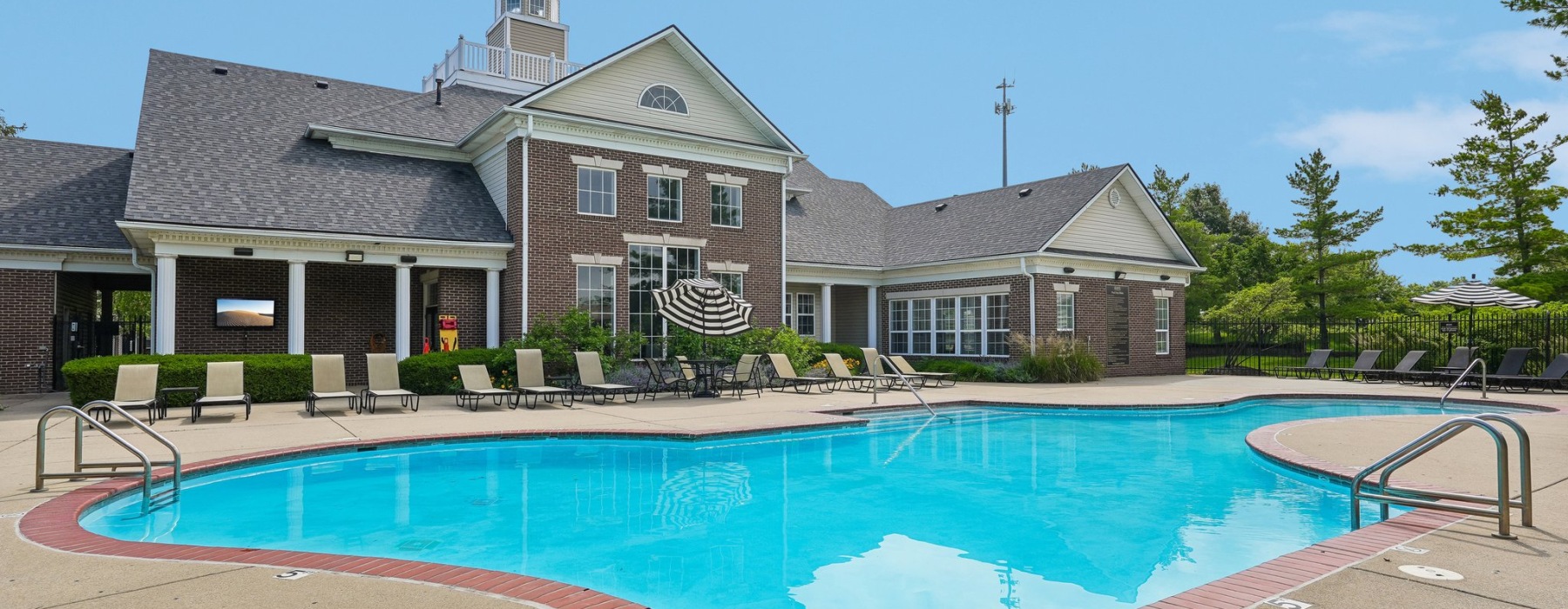 a swimming pool in front of a large brick building