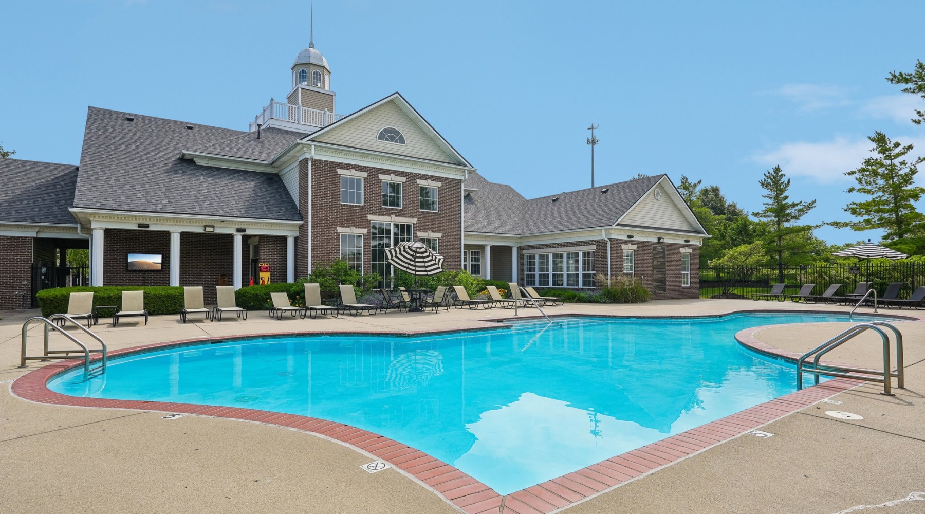 a swimming pool in front of a large brick building
