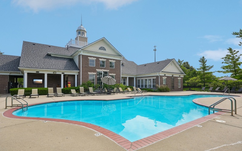 a swimming pool in front of a large brick building